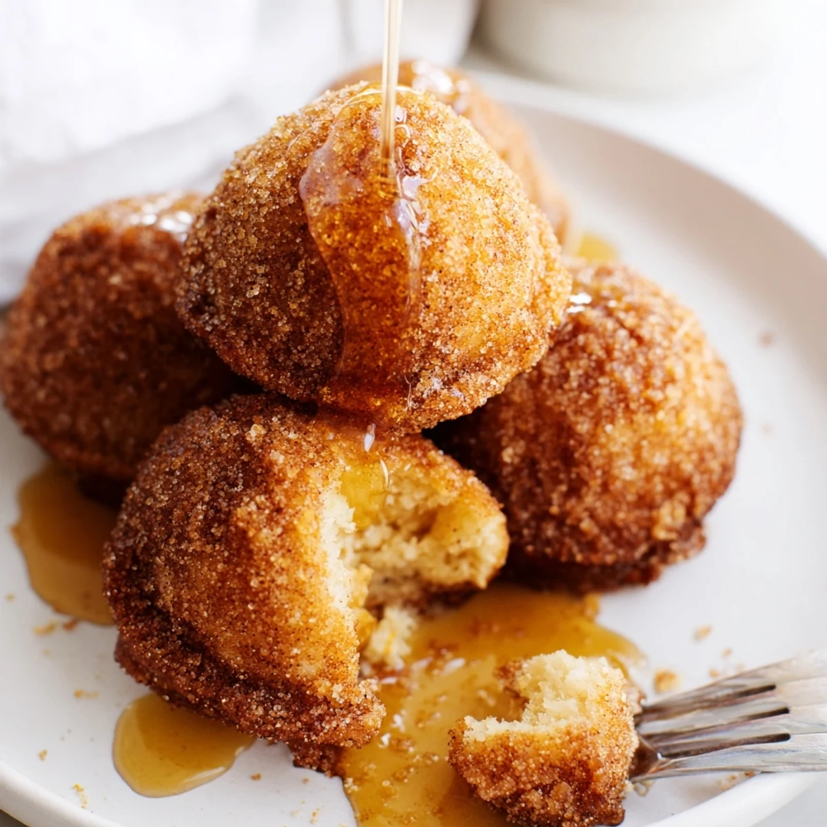 Golden-brown biscuit muffin balls filled with sharp cheddar and crystallized ginger delightfully coated.