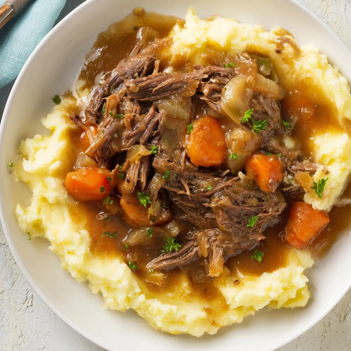 A close-up view of the savory Slow Cooker Pot Roast, beautifully plated with fluffy mashed potatoes and fresh parsley.