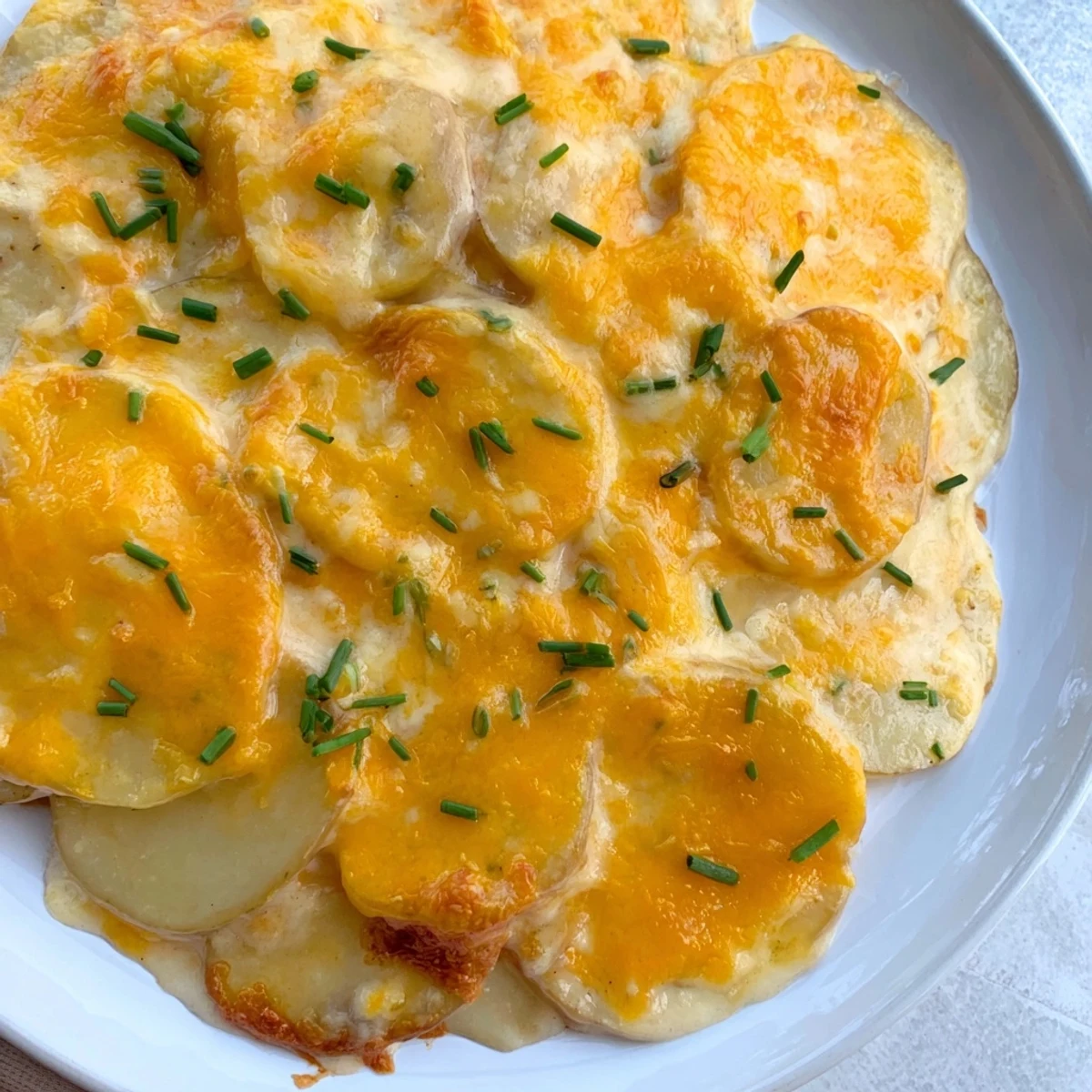 A close-up view of the delicious Cheesy Scalloped Potatoes, showing melted cheese and tender potato slices.