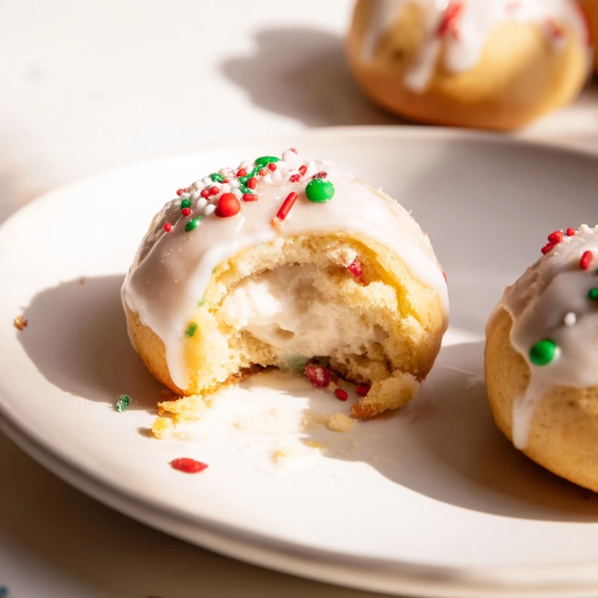Quick Christmas Biscuit Bombs displayed with drizzled glaze and colorful sprinkles, perfect for sharing.