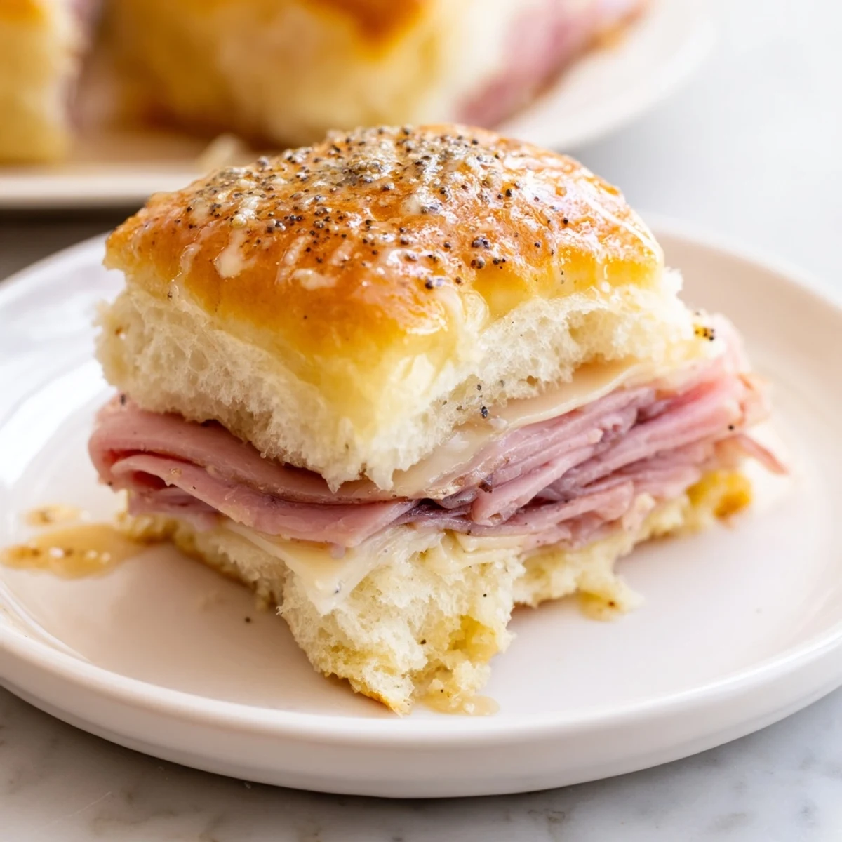 Golden brown Budget-Friendly Ham & Cheese Sliders, showcasing layers of melted cheese and savory ham.
