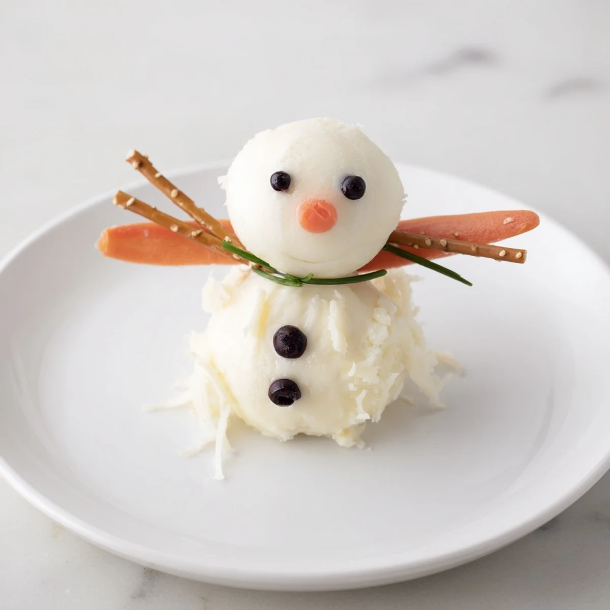 Close up of Melted Snowman Cheese Bites: cheese snowmen with olive eyes and pretzel arms on a plate.