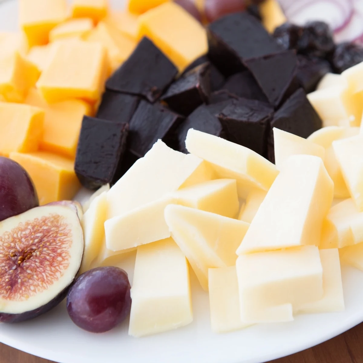 The Ghostly Outline Halloween Charcuterie Board features dark cheeses and fruits in a spooky design.