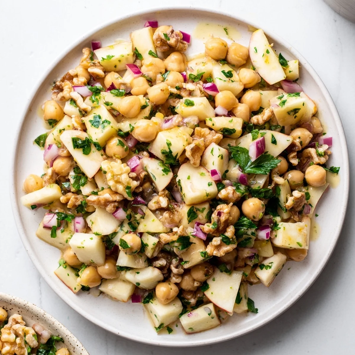 Freshly tossed Fall Harvest Apple and Chickpea Salad showing diced apples, walnuts, and a tangy dressing.