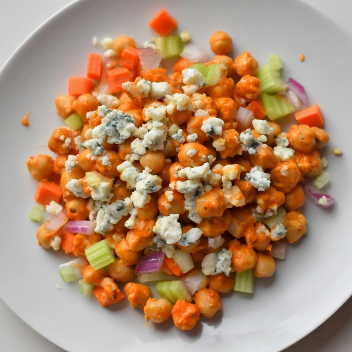 Vibrant buffalo chicken bean salad brimming with chickpeas, carrots, and spicy buffalo sauce.