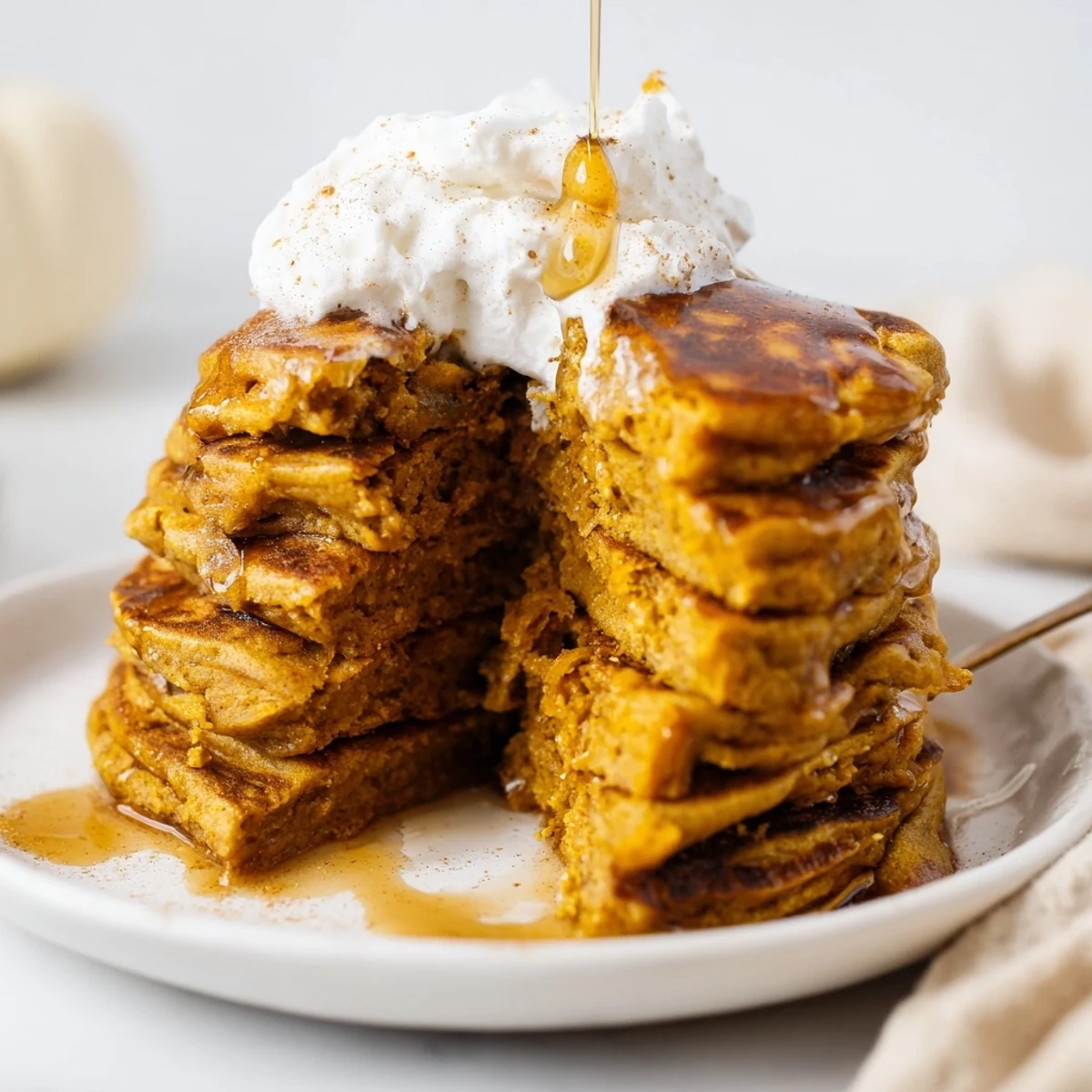 Stack of delectable pumpkin spice pancakes, cooked to perfection, ideal for a breakfast treat.