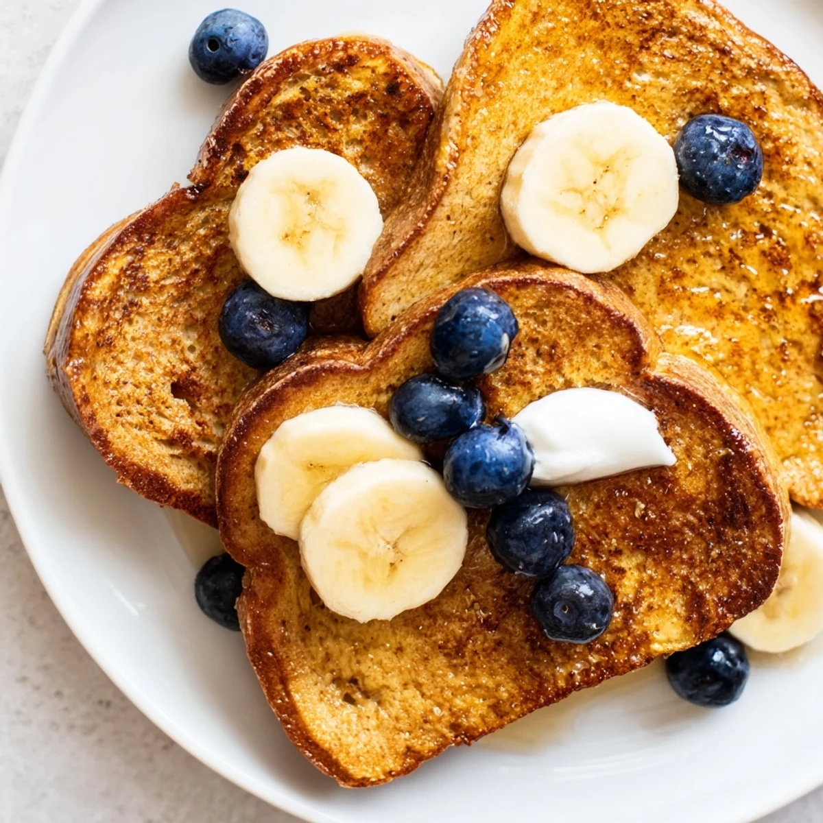 A plate of fluffy, perfectly cooked Protein French Toast, drizzled with maple syrup, ready to enjoy.