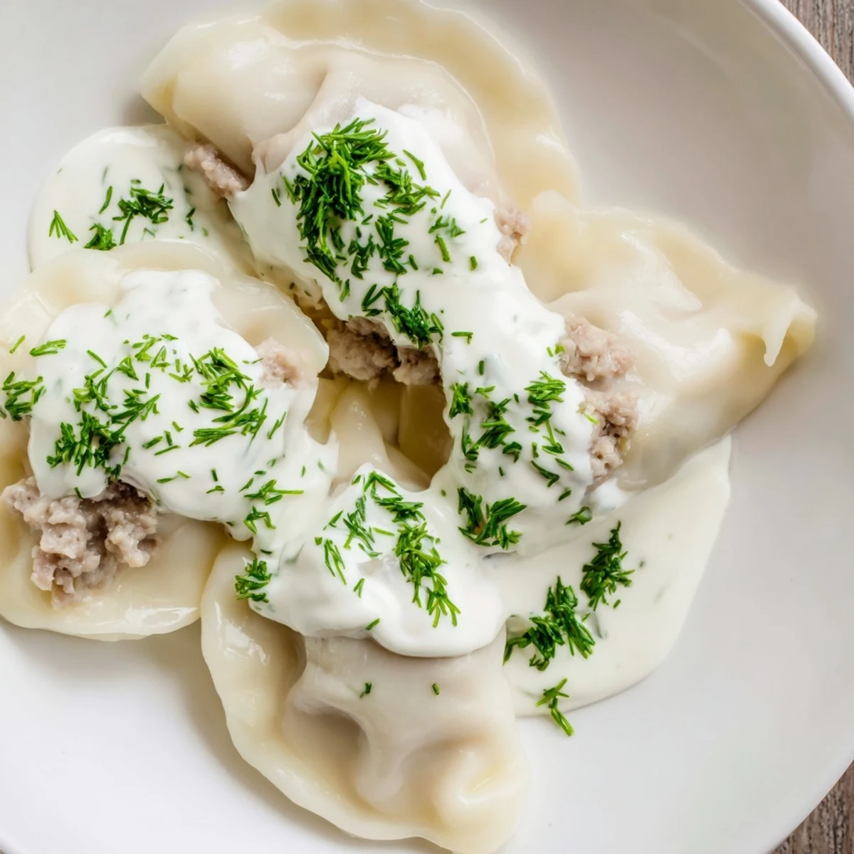 Golden, perfectly cooked Russian pelmeni, swimming in a rich sour cream sauce that's ready to eat.