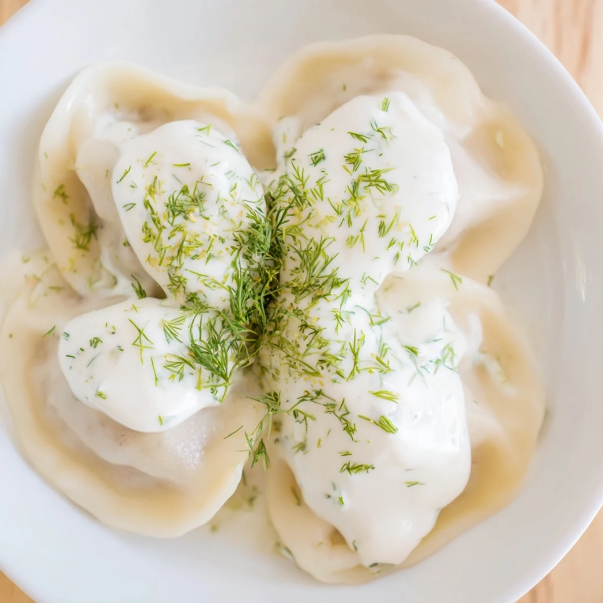 Steaming plate of savory Russian pelmeni, garnished with fresh dill and served hot for dinner.