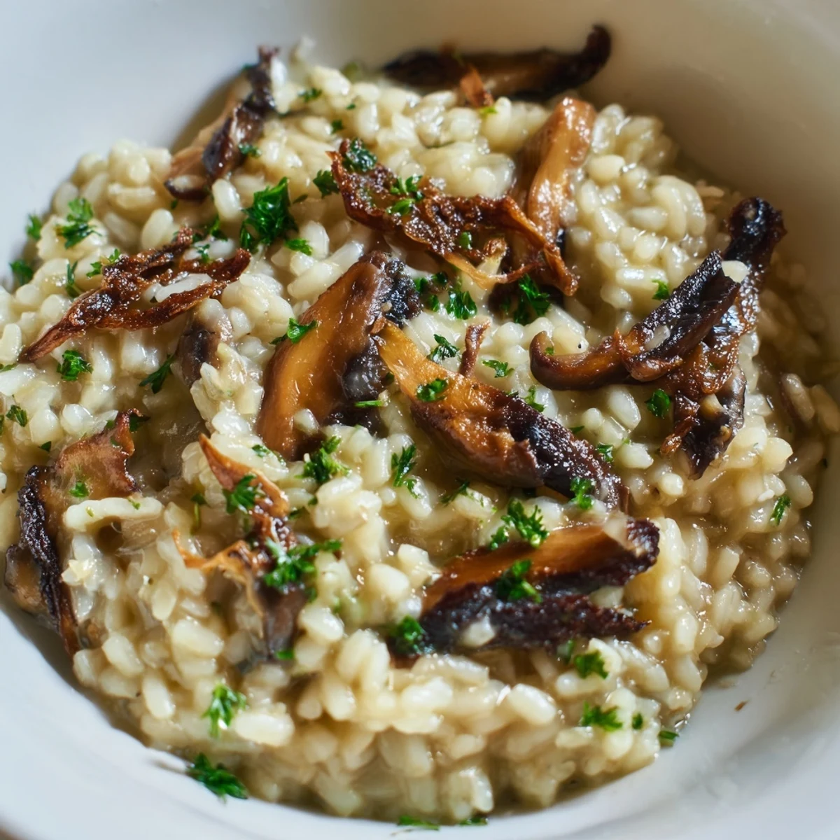 Creamy Roasted Mushroom Risotto in a white bowl, garnished with fresh parsley and extra Parmesan, ready to serve as a comforting main dish.
