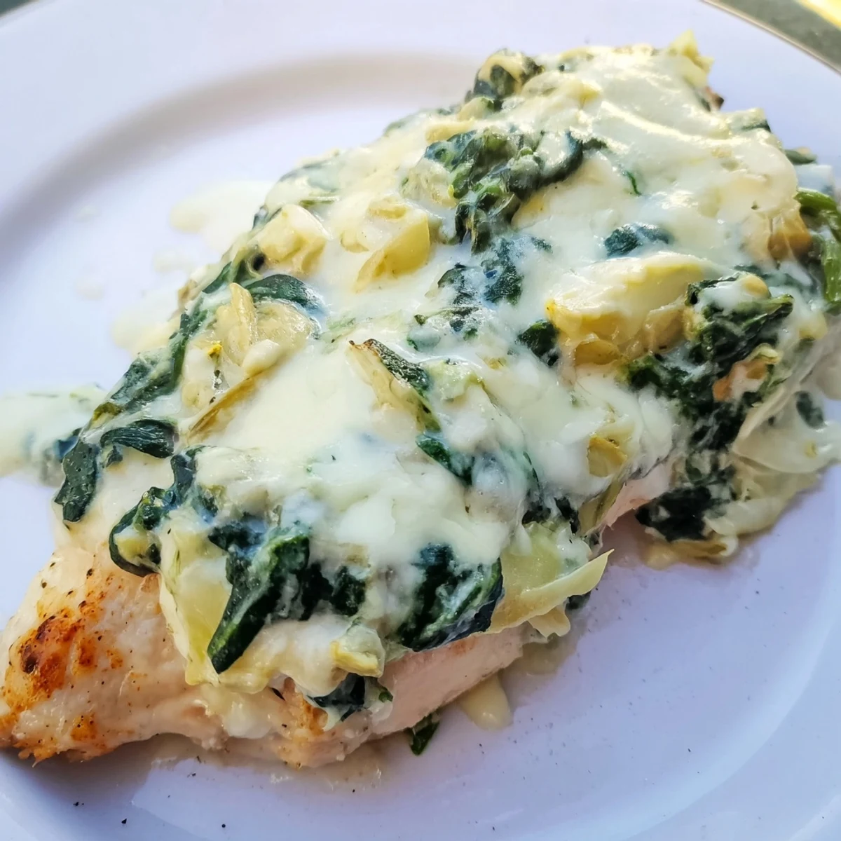 Golden-brown Spinach & Artichoke Chicken Bake emerges from the oven, bubbling with a creamy, cheesy topping.
