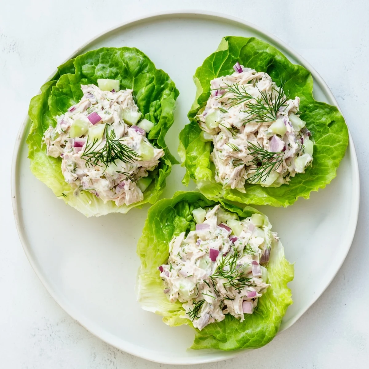 Serving suggestion for Dill Pickle Chicken Salad Lettuce Cups, with juicy chicken, fresh dill, and tangy pickles piled high on fresh butter lettuce.