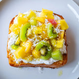 Indulgent yogurt-custard toast features coconut yogurt and fresh fruit medley for brunch delight.  