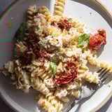 Deliciously cheesy Baked Feta Pasta drizzled with olive oil and fresh basil.  