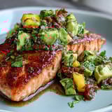 Oven-baked salmon fillets served with colorful mango avocado salsa, perfect for a healthy, flavorful meal.  