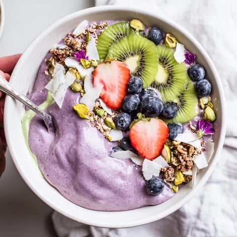 Vibrant smoothie bowls with purple yam and fresh fruit toppings for a nutritious breakfast.  