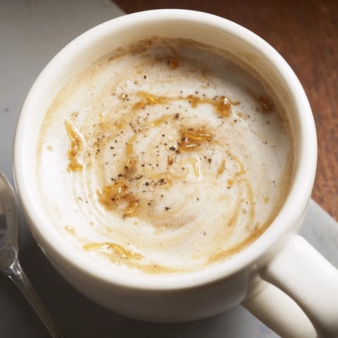 Savory onion latte topped with frothy milk and caramelized onion purée.  