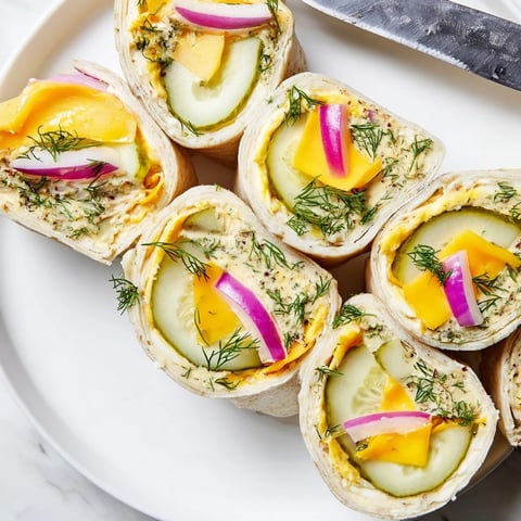 Crispy Pickle-in-a-Blanket snack bites wrapped in tortillas with creamy cheese.  
