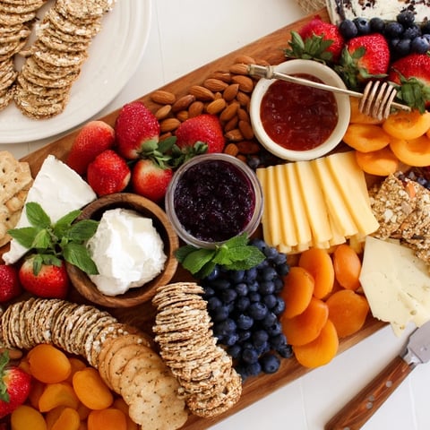 Vibrant jam-infused brunch board with cheese, fruits, and artisan breads beautifully arranged.  