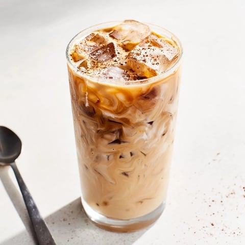 Indulge in a creamy Tahini Iced Coffee topped with vibrant plant-based milk.  