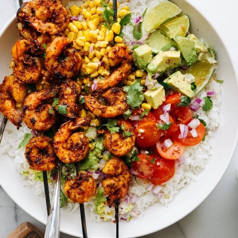 Juicy grilled shrimp bowl topped with creamy avocado corn salsa and lime zest.  