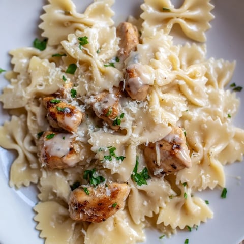 Savory Mozzarella Garlic Butter Chicken Bowties topped with melted cheese and fresh parsley.  