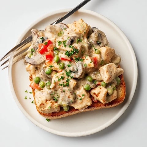 Creamy Chicken à la King served over warm, buttery toast, ideal for dinner.   