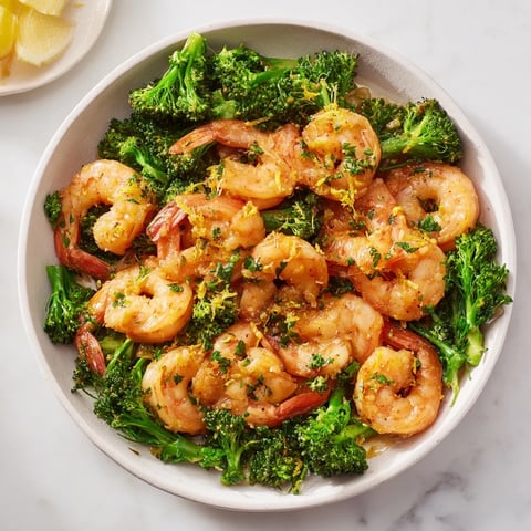 Golden, pan-seared lemon butter shrimp & broccoli with vibrant green broccoli florets, ready to serve.