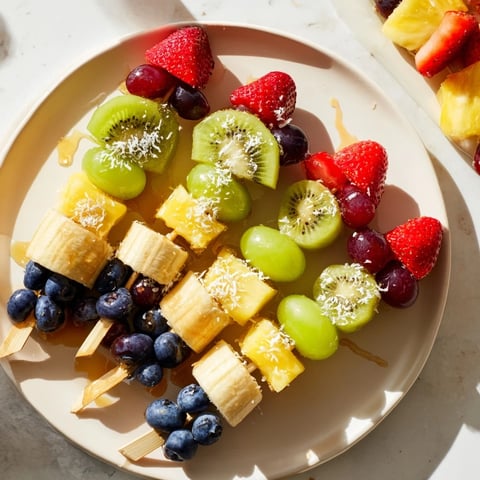 Easy festive fruit kabobs, vibrant with strawberries, grapes, and pineapple, perfect for a summer snack.