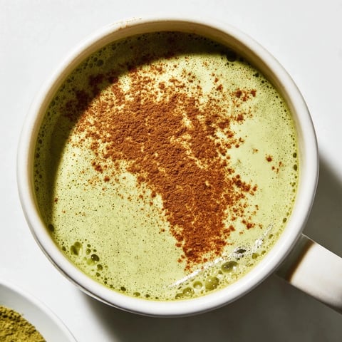 Steaming Cinnamon Maple Oat Milk Matcha Latte, a vibrant green vegan beverage, ready to enjoy.