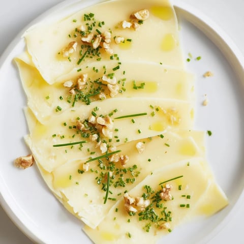 A beautifully arranged Swiss Cheese Slices fan, sprinkled with chives, ideal as an appetizer.
