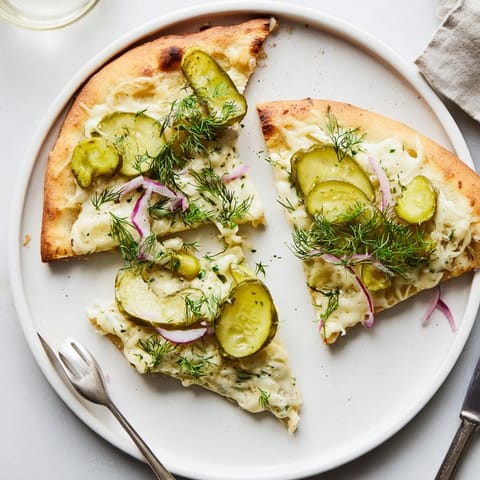 Delicious pickle pizza topped with rich crème fraîche and fresh dill finishing.  