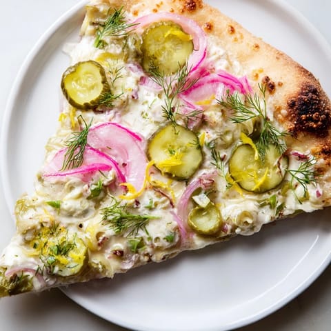 Tangy Pickle Pizza from the oven, featuring melted mozzarella and fresh garnishes.  