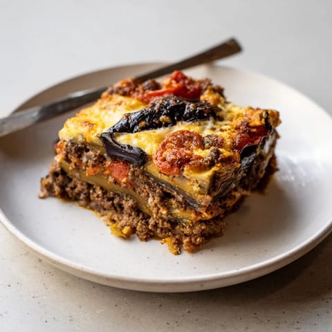 Layers of savory moussaka with beef, eggplant, and a golden cheese crust.  