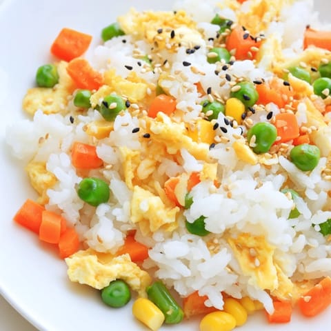 Steaming Frozen Veggie Fried Rice with soy sauce, offering a quick, delicious vegetarian meal that's perfectly seasoned.