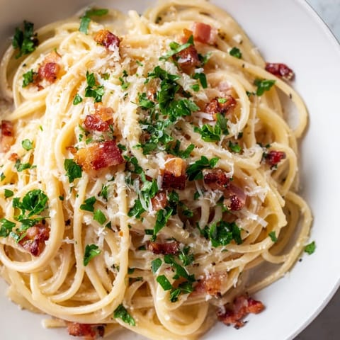 Golden, crispy bacon tops this amazing creamy garlic bacon pasta, ready for a satisfying Italian meal.