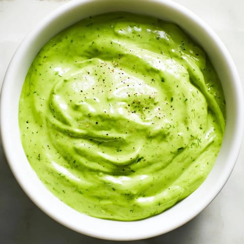Creamy homemade Green Goddess Dressing, perfectly blended with fresh herbs, ready to drizzle over a salad.
