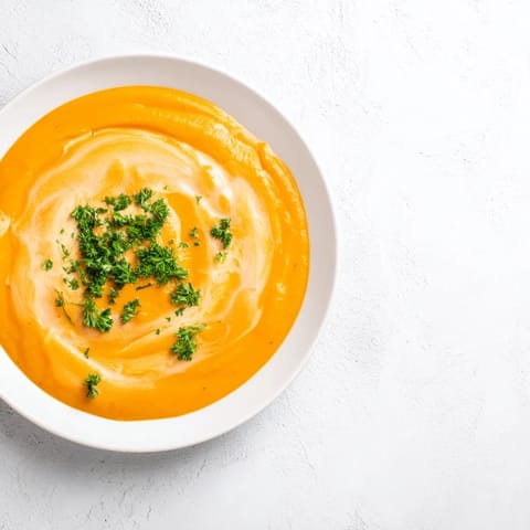 Golden-orange creamy carrot soup, a vegetarian delight, perfect for a cozy weeknight dinner.