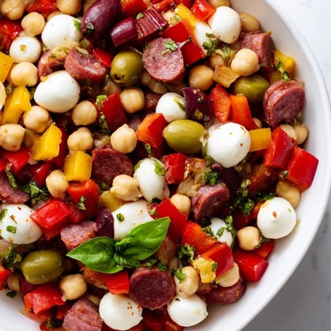 A vibrant bowl of Crunchy Antipasto Chopped Salad with chickpeas, salami, and mozzarella in zesty dressing.  