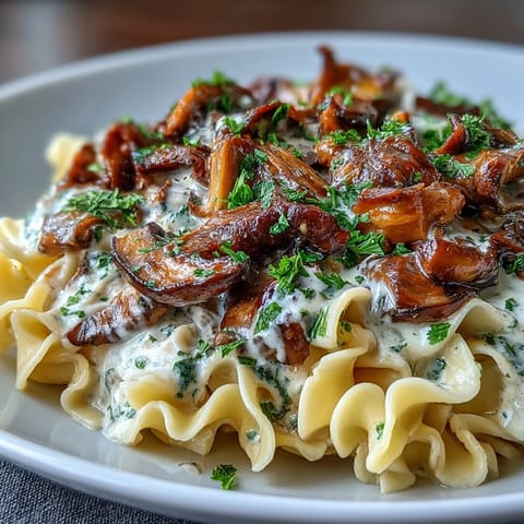 Steaming Creamy Mushroom Stroganoff with sautéed mushrooms and sour cream sauce in a skillet