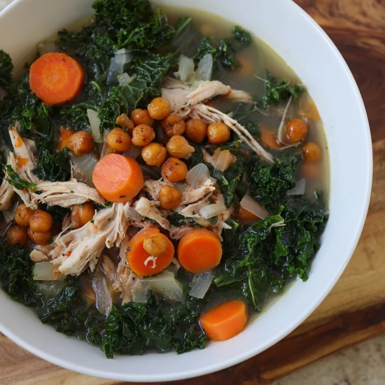 Enjoy a steaming bowl of Chicken Kale Soup, garnished with crispy chickpeas, perfect for a cozy night.