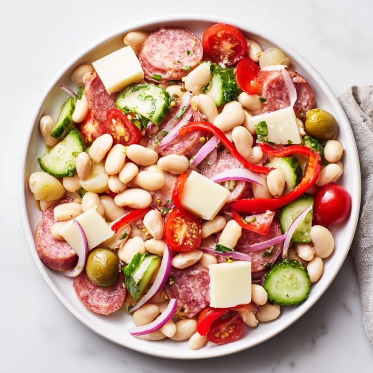 Fresh Italian antipasto bean salad with creamy cannellini beans, delicious salami, and a tangy dressing.