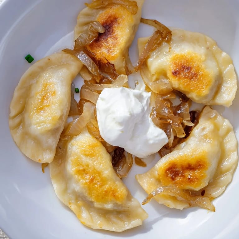 A close-up of delicious Polish pierogi, tender dumplings filled with potato and cheese, ready to eat.